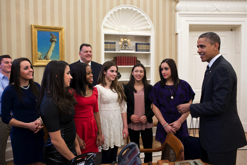 President Obama talking with a small group of young women in an office space